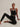 Model seated in the Varley Always Jay Bra in Black/Snow White with matching leggings.