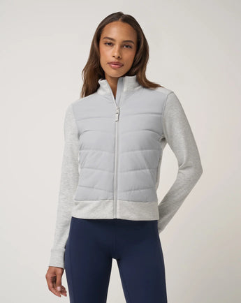 TravisMathew Soft Quilted Full Zip Jacket in Heather Light Grey, front view on model with zipper closed.