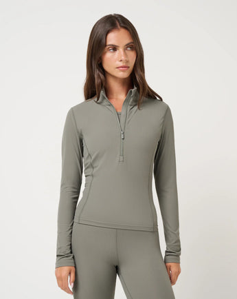 TravisMathew Pulse Half Zip in Olive Smoke, front view showing fitted shape, long sleeves and ribbed texture.