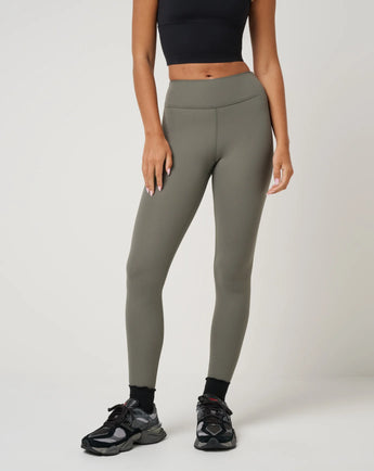TravisMathew Pulse Legging in Olive Smoke, front view showing high-rise waistband and full-length fitted legs.