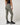 TravisMathew Pulse Legging in Olive Smoke, rear three-quarter view showing ribbed texture and fitted silhouette.