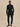 Front view of the black Varley Anset Jacket on a model, showing the high collar, tied waist and longline silhouette.