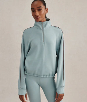 Varley Sian cropped half-zip midlayer in Tourmaline with a stand collar and dark sleeve piping