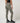 TravisMathew Pulse Legging in Olive Smoke, rear three-quarter view showing ribbed texture and fitted silhouette.