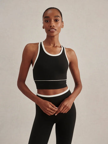 Varley Always Jay Bra in Black/Snow White, showing its high neckline, white contrast trim and wide underband.