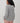 Back view of the Varley Melchie Relaxed Knit Hoodie in Grey Marl, showing its hood, open pointelle stitch and ribbed hem.